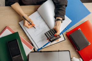 woman using a calculator to complete paperwork
