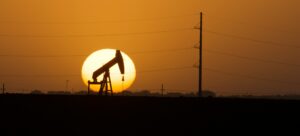 Oil well working while the sun is setting